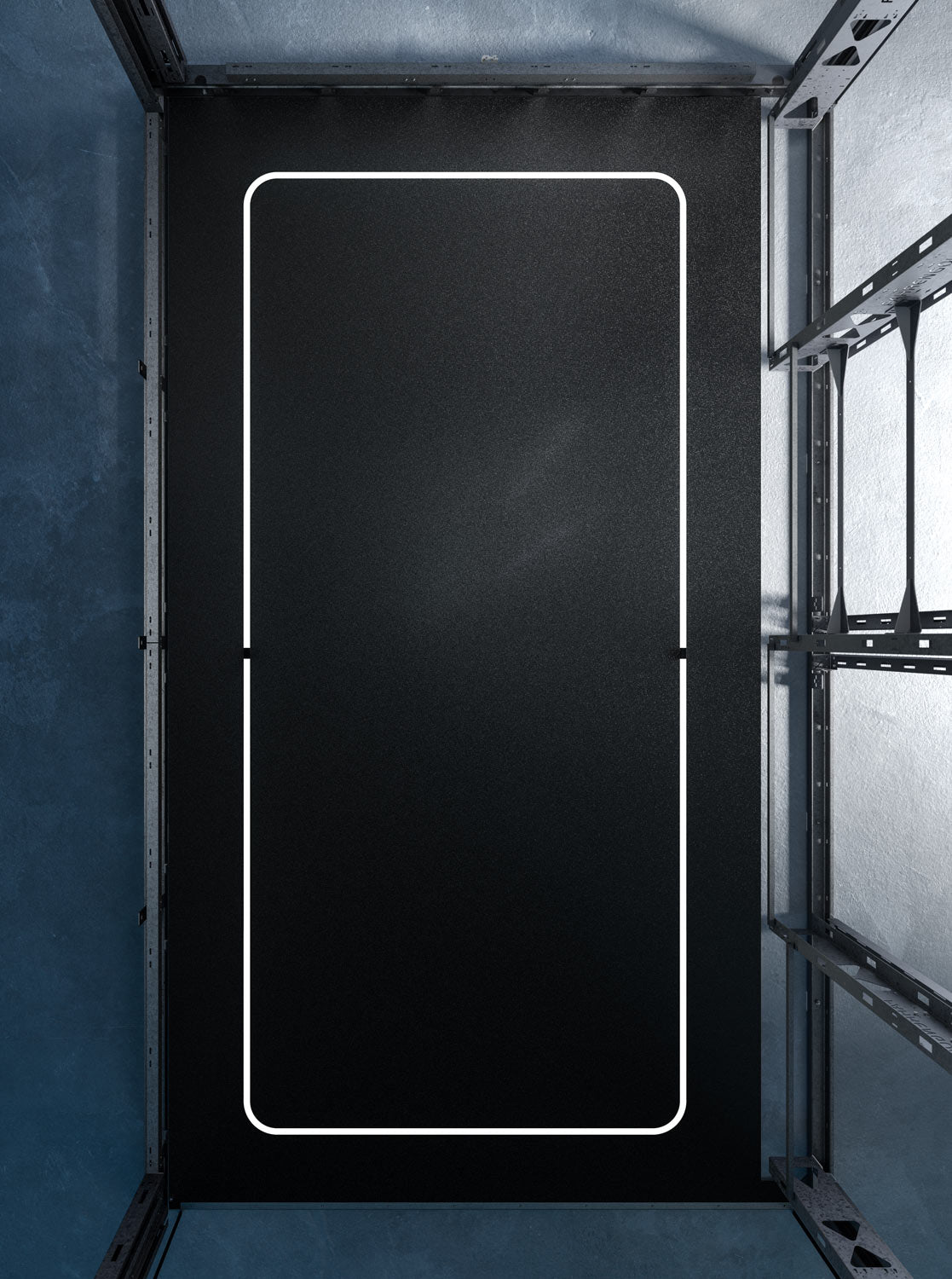 Schwarzes Fahrzeug-Pad mit weißem Rahmen in einem Garagenbereich, umgeben von Metallstrukturen.