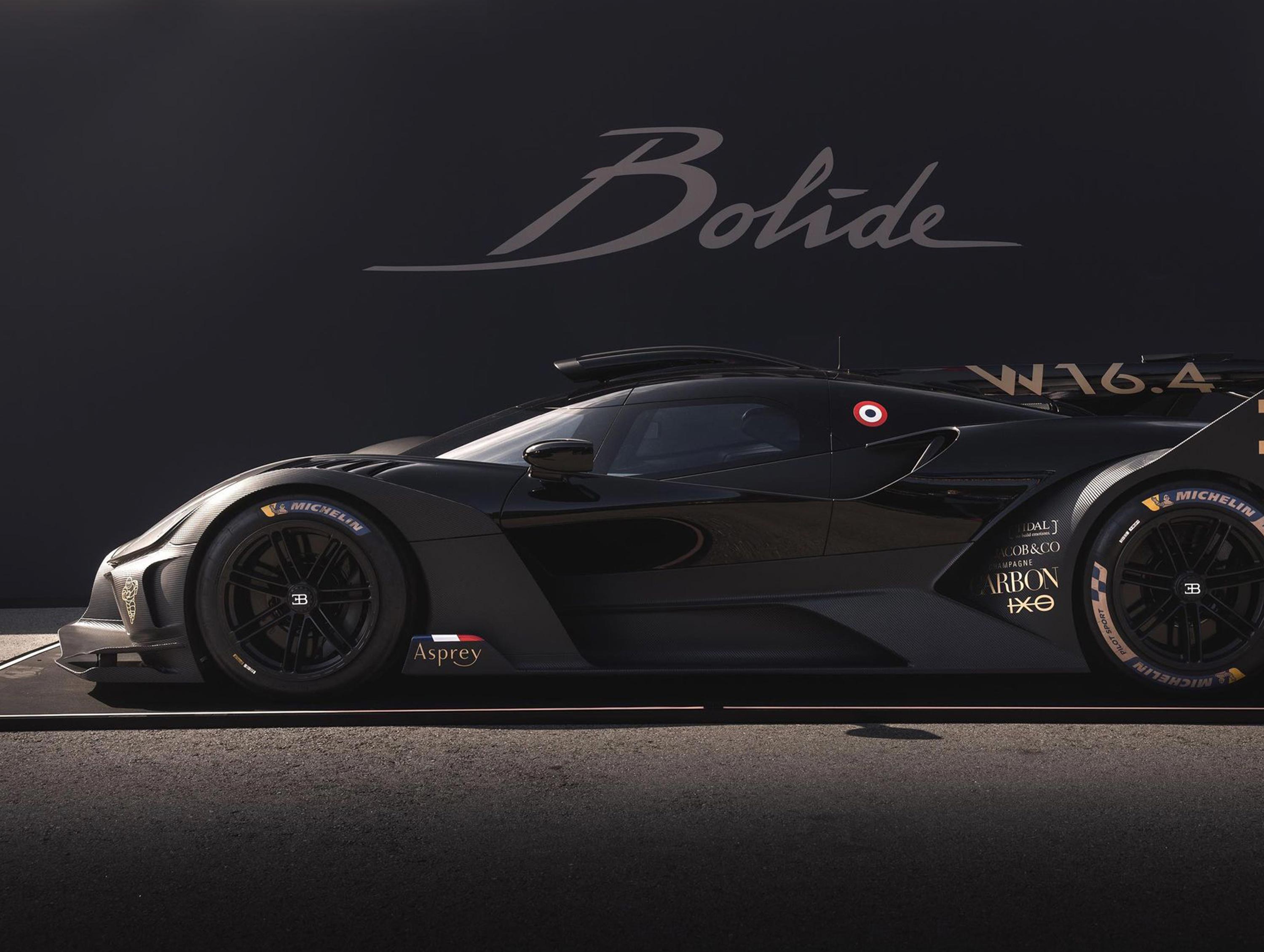 Schwarzer Supersportwagen seitlich vor dunklem Hintergrund mit "Bolide" und "W16.4"-Schriftzug.