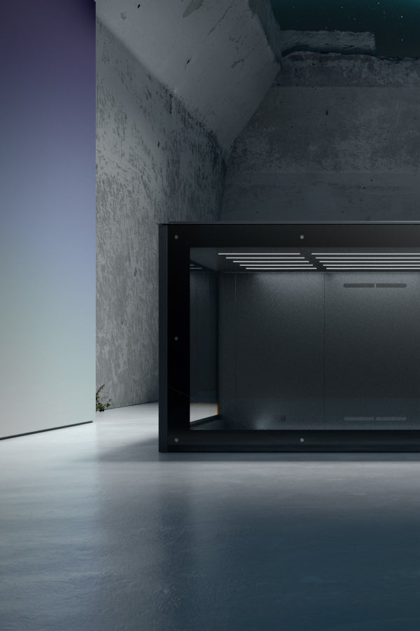 Schwarzes, rechteckiges Objekt in einem minimalistischen Raum mit grauer Betonwand und glattem Boden.