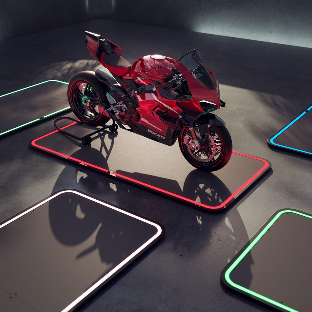 Rotes Motorrad steht auf einem von LEDs beleuchteten Fahrzeugpad in einem dunklen Raum.