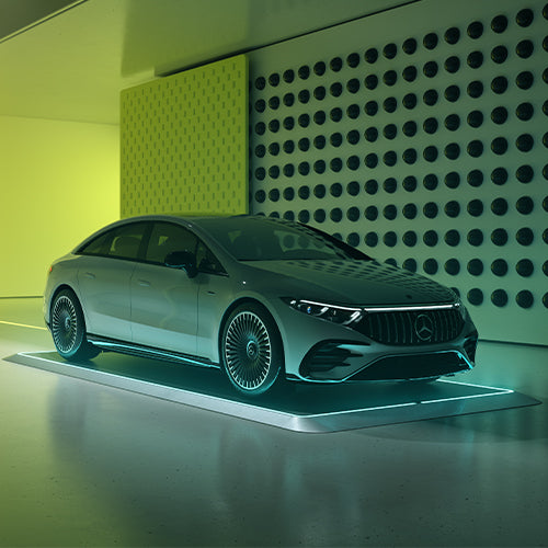 Silbernes Auto auf beleuchtetem Pad in einem modern gestalteten Raum mit perforierter Wand.